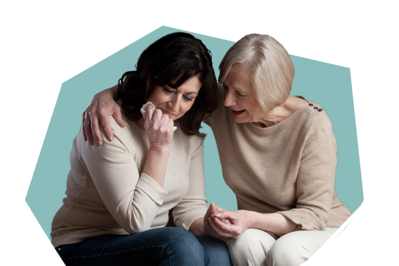 An image of a woman supporting another woman through her grief.